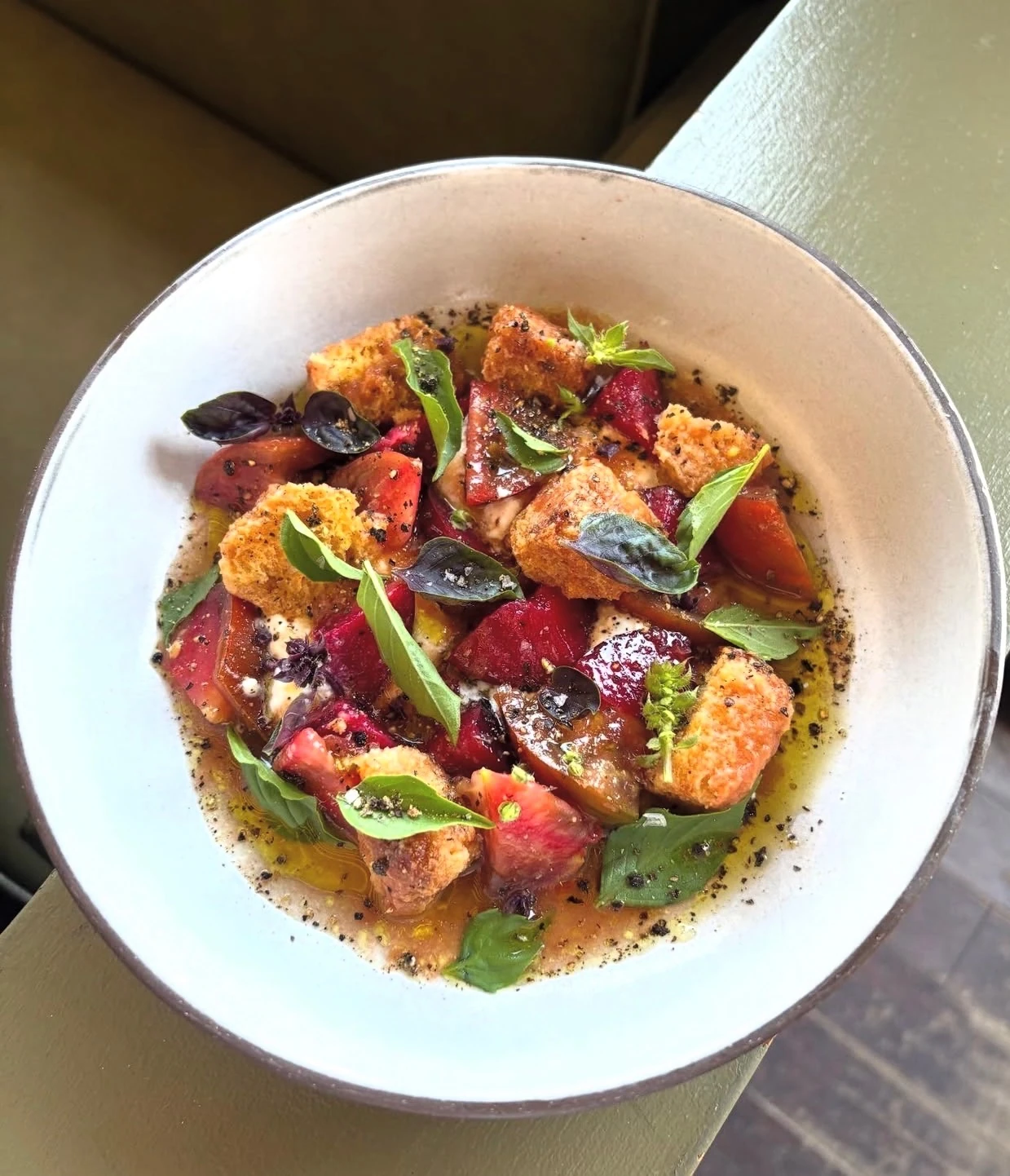 Top-down bowl of panzanella — toasted bread, red and yellow tomatoes, fresh basil in olive oil — a Montecito private-chef dish by Ania's Table